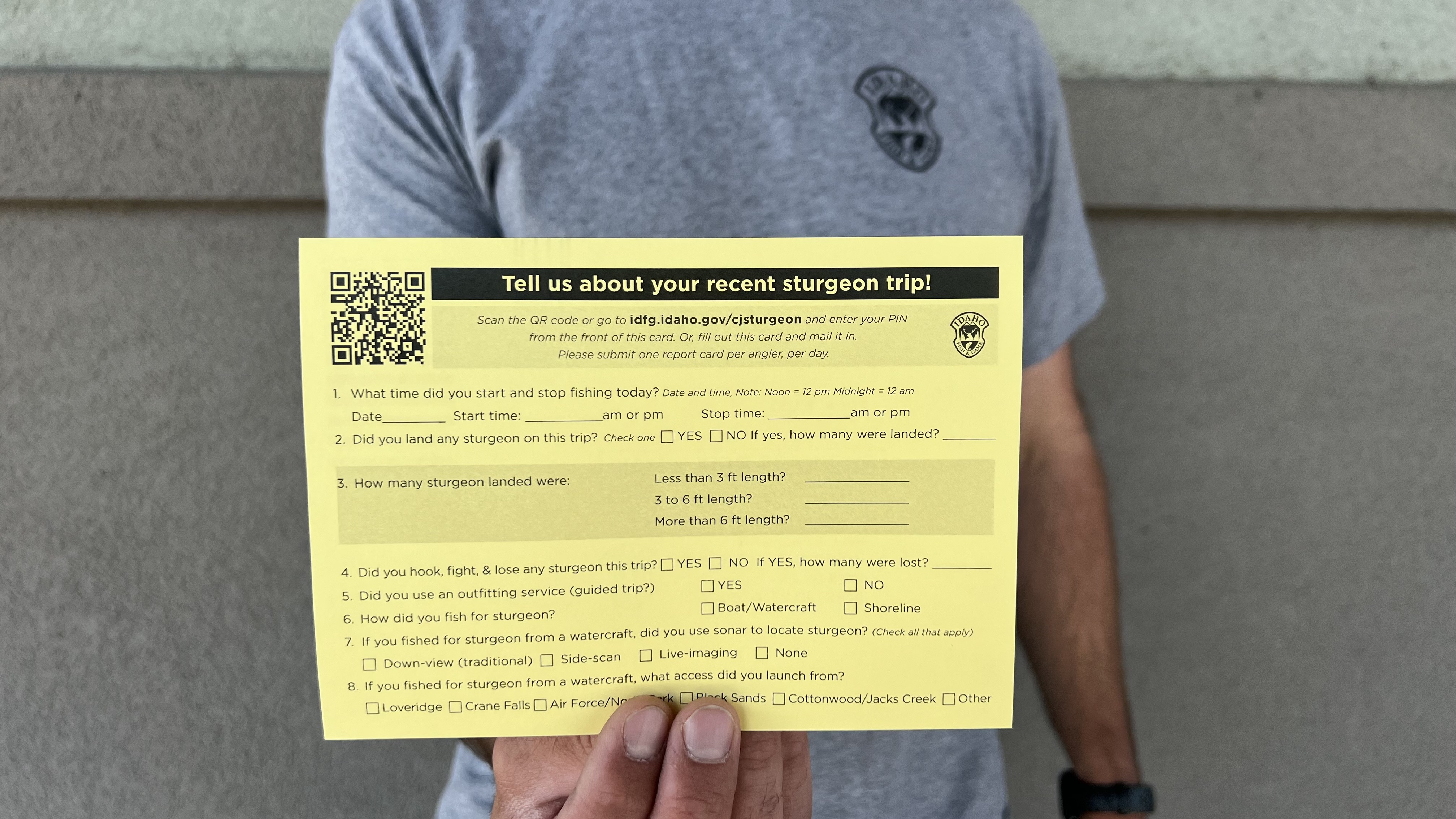 Fisheries biologist Phil Branigan holds up a sturgeon angler report card for the 2023 survey at C.J. Strike