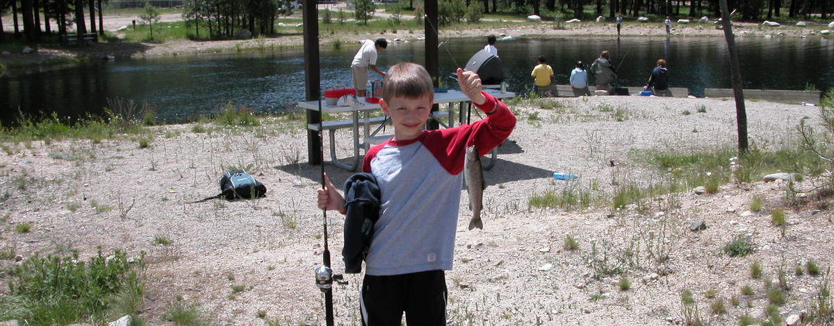 a boy showing off his catch at the Lowman fish pond June 2006