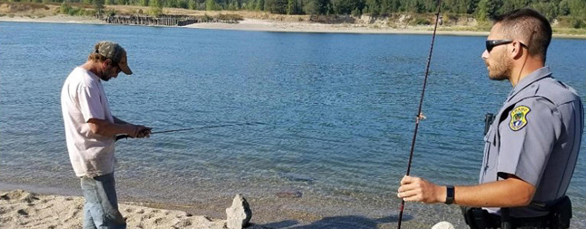 Conservation Officer checks an anglers license