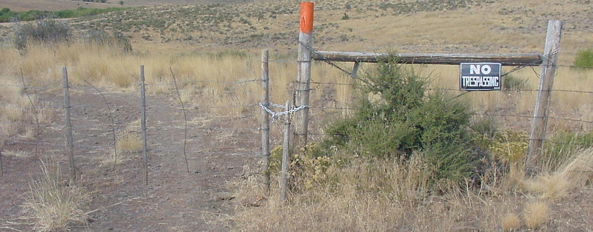 medium shot of a posted no trespassing sign and orange painted fence post September 2005