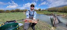 Biologist Nathan Tillotson holding a large cutthroat trout